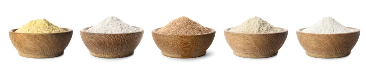 A line of five small wooden bowls each with a different flour. 