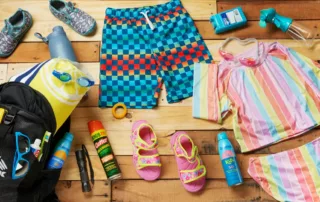 Summer camp supplies on wooden table flat lay