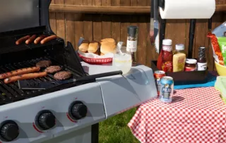 Grill with hamburgers, hot dogs and condiments