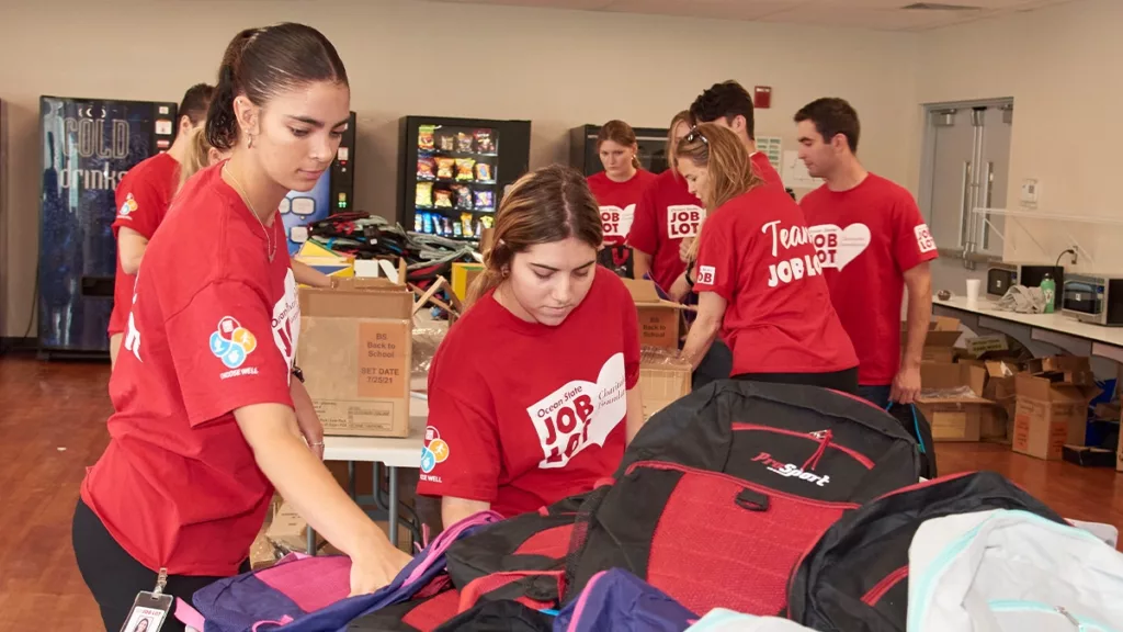 A group of Ocean State Job Lot Interns volunteer to fill Buy Give Get Backpacks with donated school supplies for children of military families in need in August, 2022.