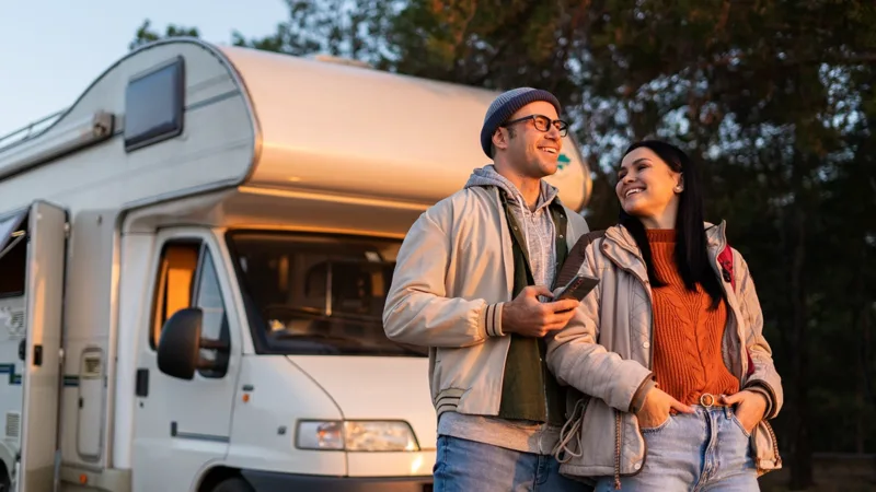 Two people standing in front of a mobile camper