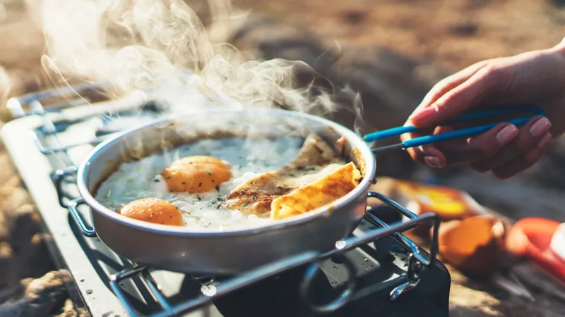 Cooking eggs on a portable grill in the morning.