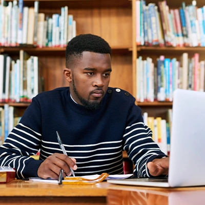 Man studying on computer in library