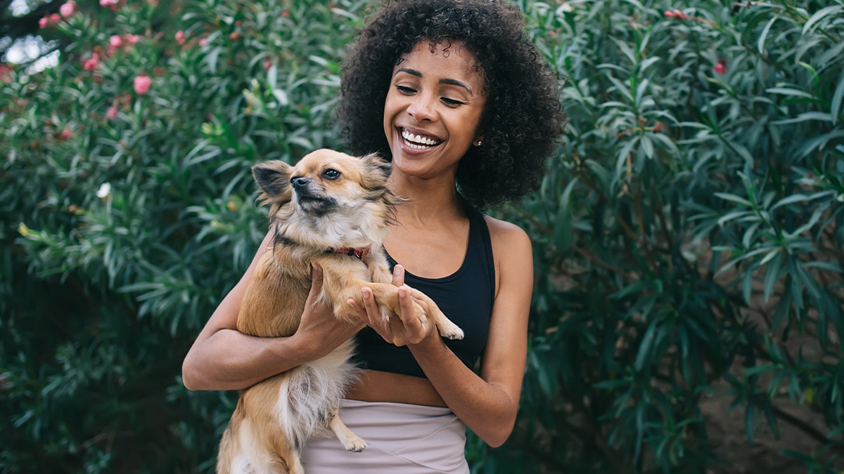 Woman smiling and holding dog