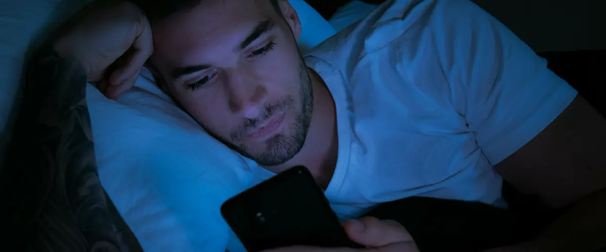man on his phone in bed