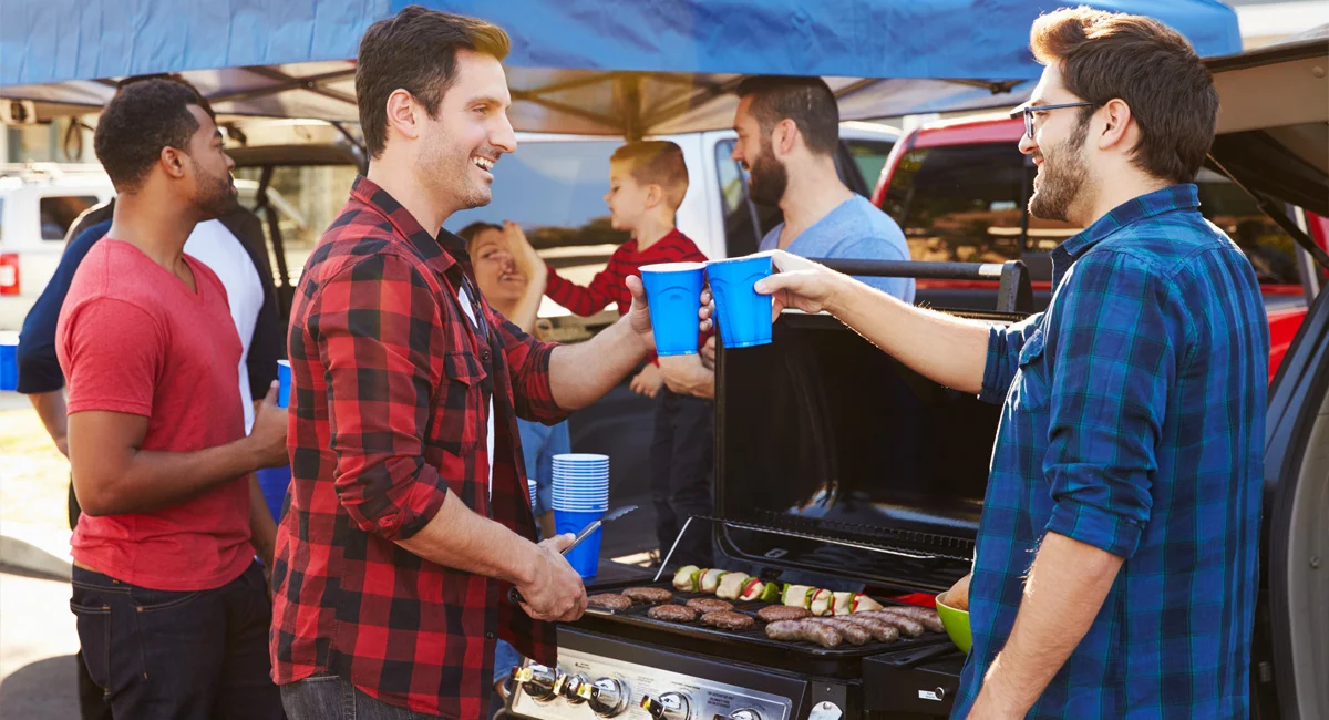 Friends talking at a tailgate party with drinks