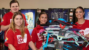 Ocean State Job Lot volunteers filling backpacks with supplies for children going back to school as part of the Buy-Give-Get Backpacks program in August of 2022.