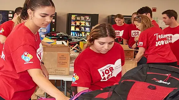 Ocean State Job Lot volunteers filling backpacks with supplies for children going back to school as part of the Buy-Give-Get Backpacks program in August of 2022.
