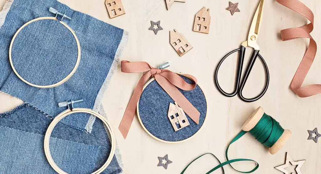 Crafting Christmas ornaments with denim fabric, ribbon, and wooden decoratons