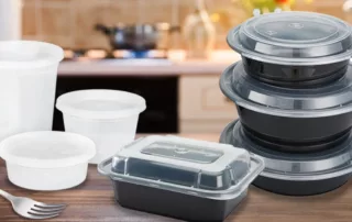 Various sizes of take out containers stacked on a kitchen counter.