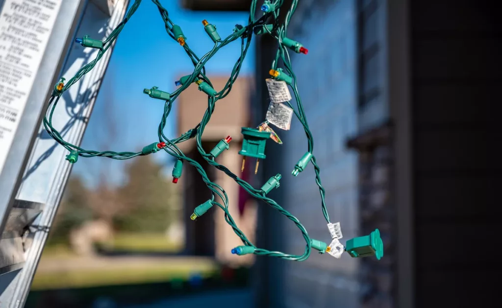 Outdoor holiday light sets being strung.