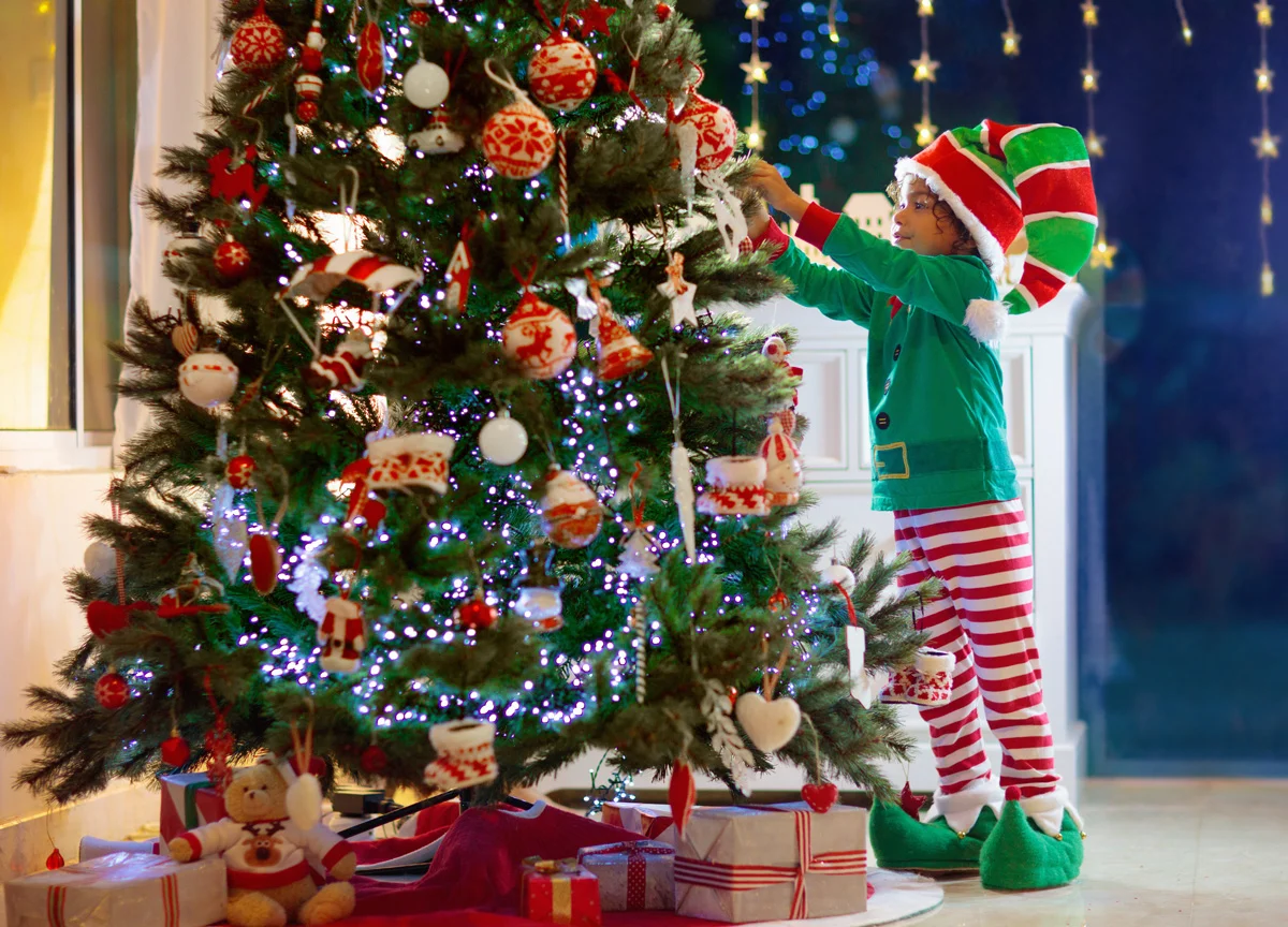 Child decorating Christmas tree.