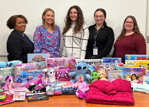 Members of the OSJL Marketing department wrap toys for Foster Forward