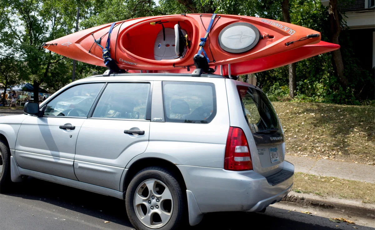 A pair of kayaks being transported on top of a car.