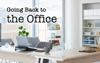 A tidy, light-filled office space with text that reads "Going Back to the Office"