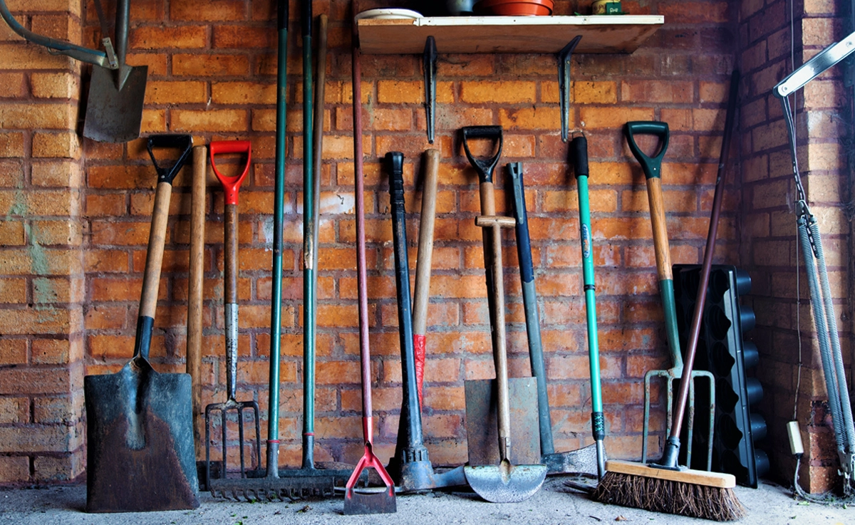 Garden tools laid out in a garage.
