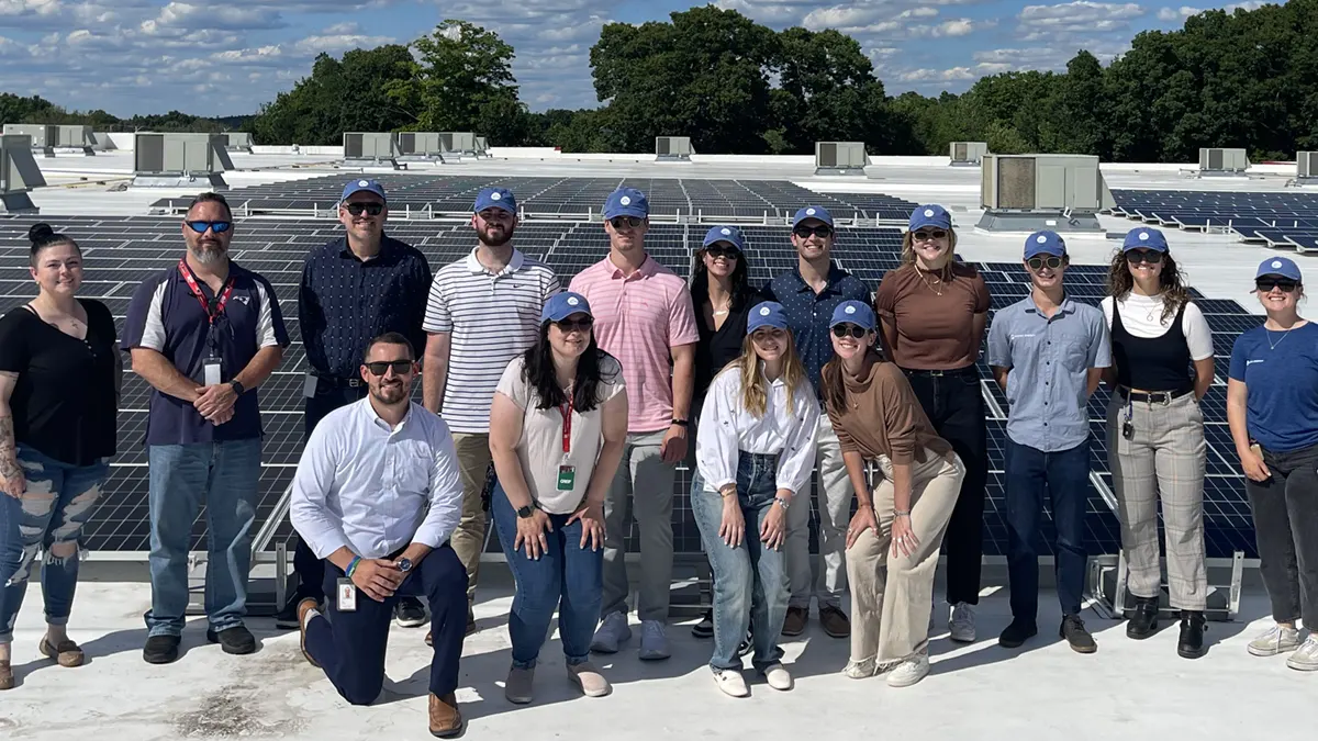 Ocean State Job Lot interns with our sustainability team in front of solar panels on the roof of our corporate office.