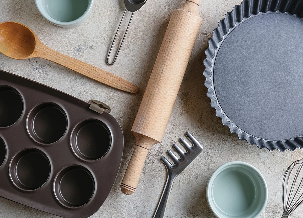 A table with an assortment of pie pans, rolling pins, and bakeware.