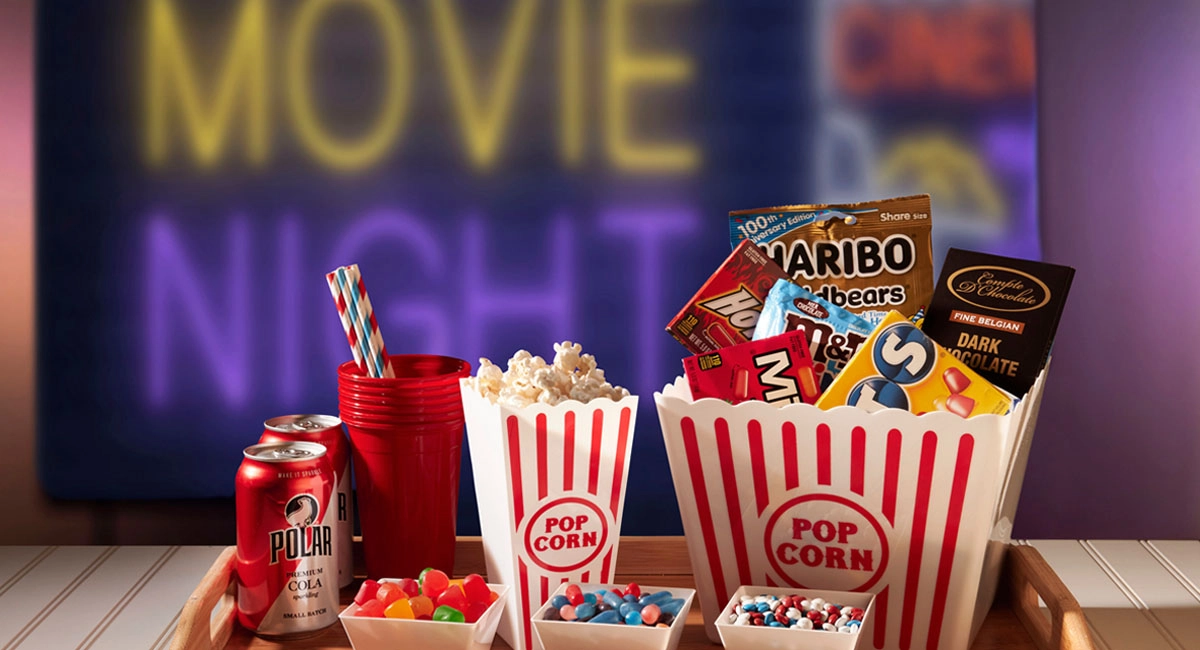 Snacks on a tray in front of a movie night sign.
