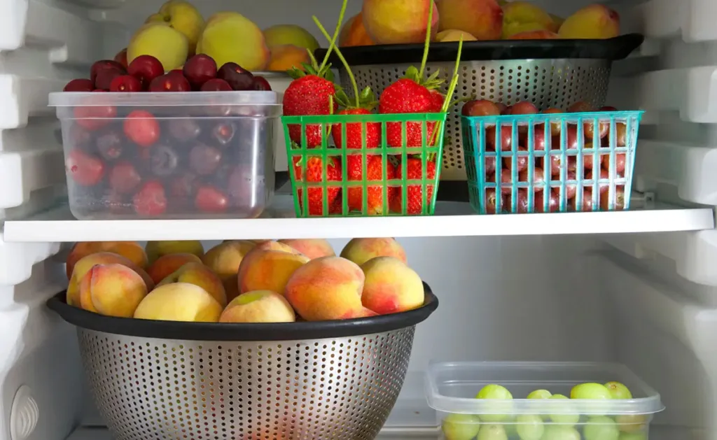 A refrigerator organized with fruits and vegetables.