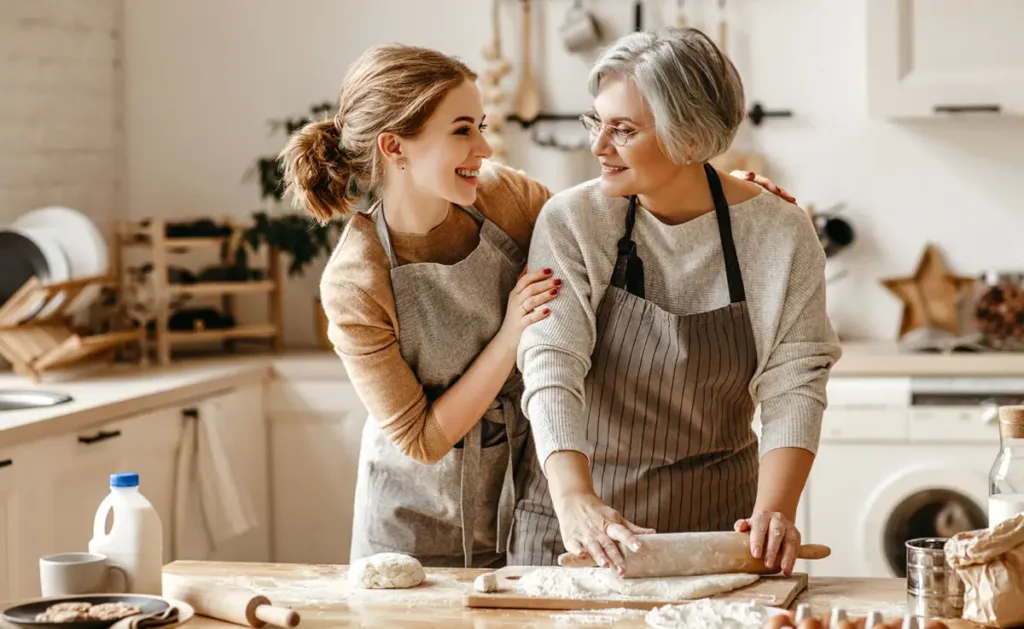 A mother and daughter baking cookies together in the kitchen.