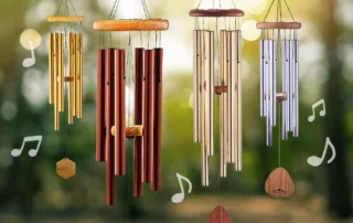 Windchimes in assorted colors hanging in a forest environment.