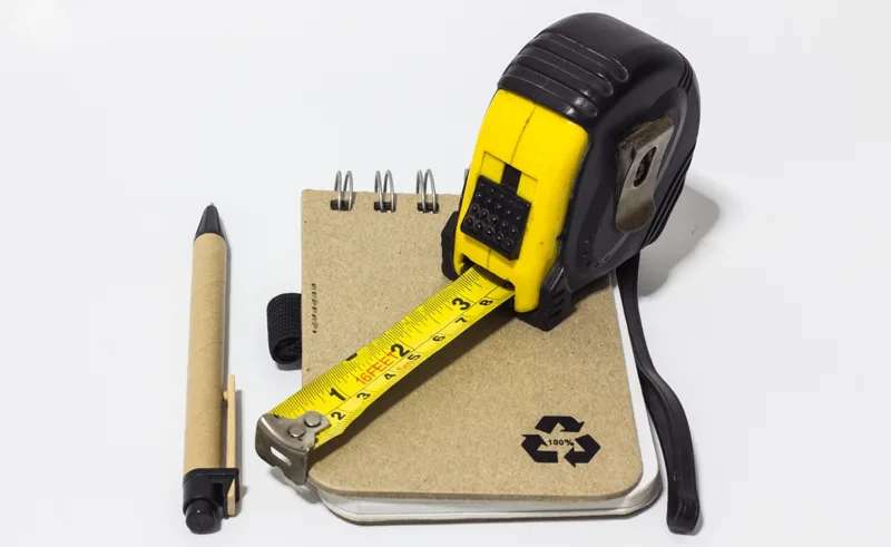 A pencil, notebook and tape measure.