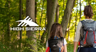 Two people hiking in the woods wearing hydration backpacks