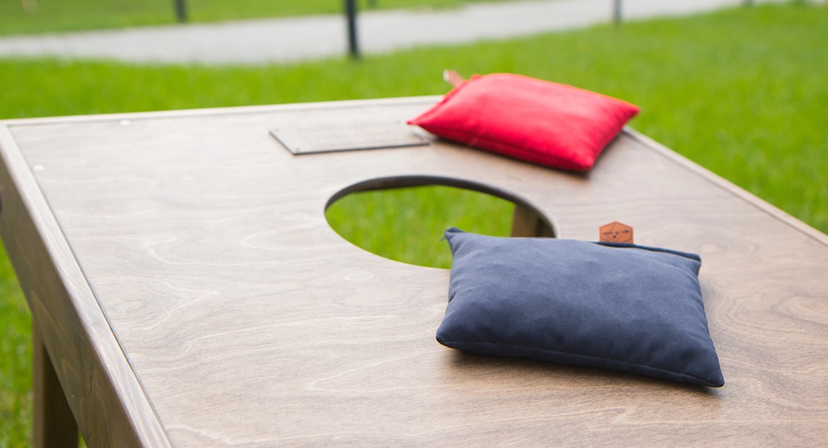 Close-up view of a cornhole board and 2 bean bags.