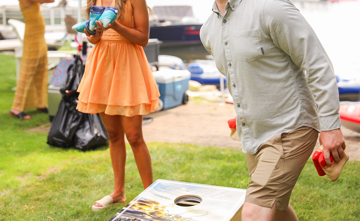 Two people playing cornhole.