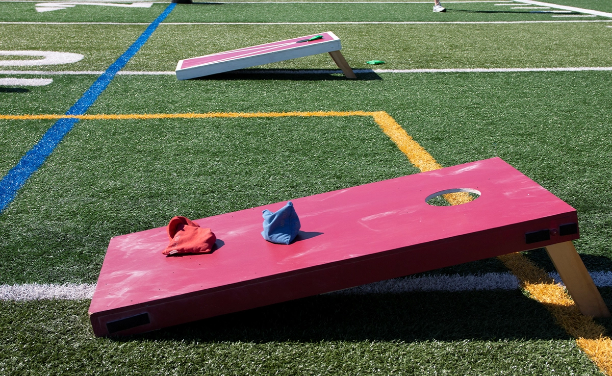 Two cornhole boards on a stadium field.