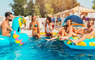 Adults having fun in the pool at an outdoor summer party