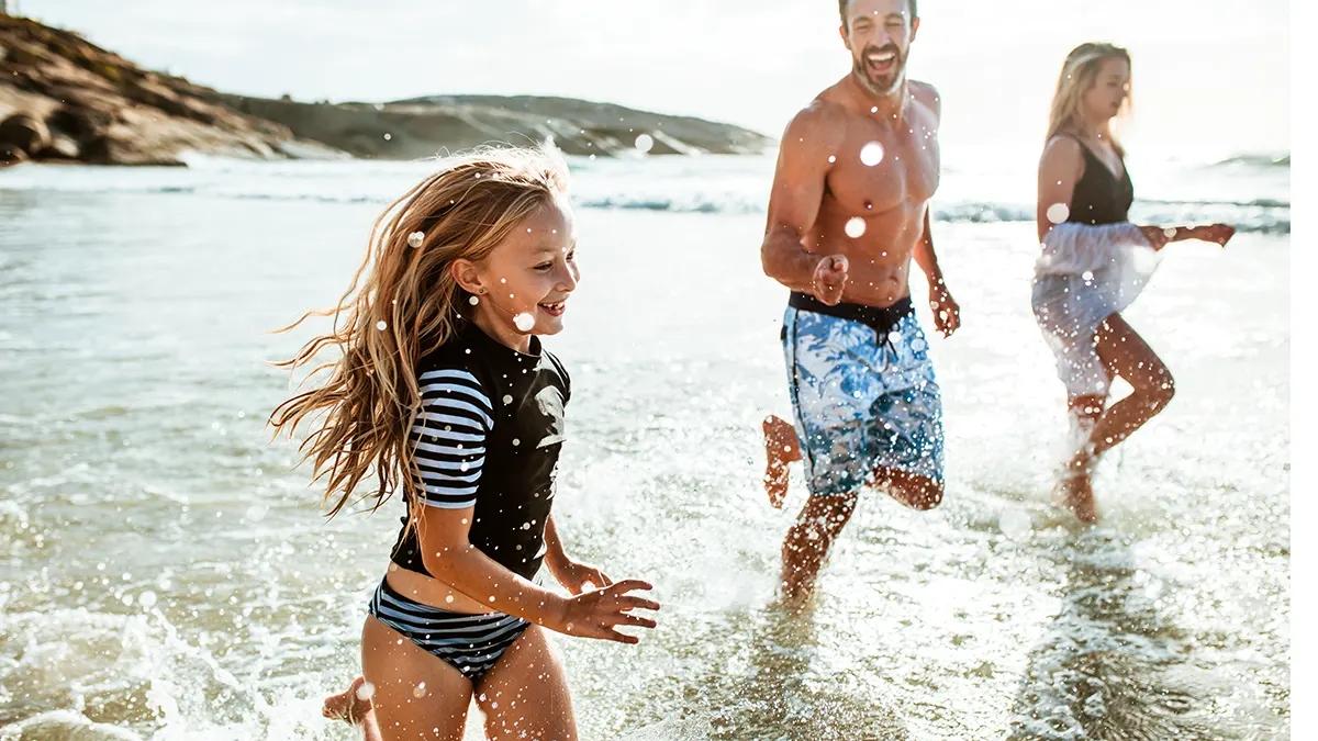 Family running in the water at beach