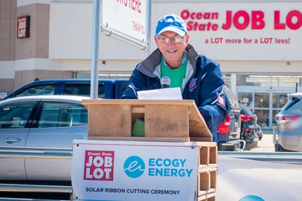 A person speaking at a podium in front of an Ocean State Job Lot store.