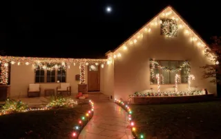 A house at night decorated with Christmas lights.