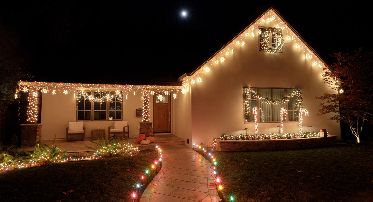 A house at night decorated with Christmas lights.