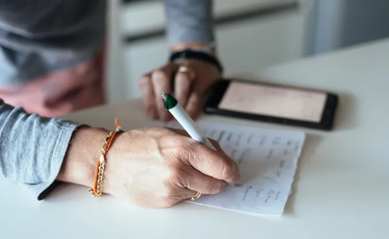 A person writing a shopping list.