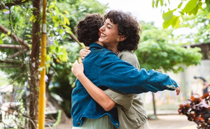 Two friends embrace in a hug.