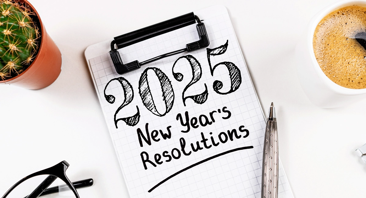 A clipboard with a written note that reads "2025 New Year's Resolutions"