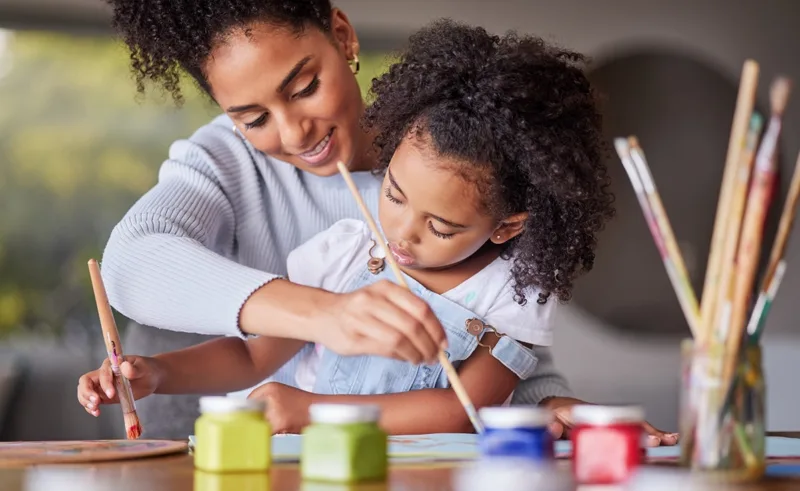 A mother and daughter painting together.