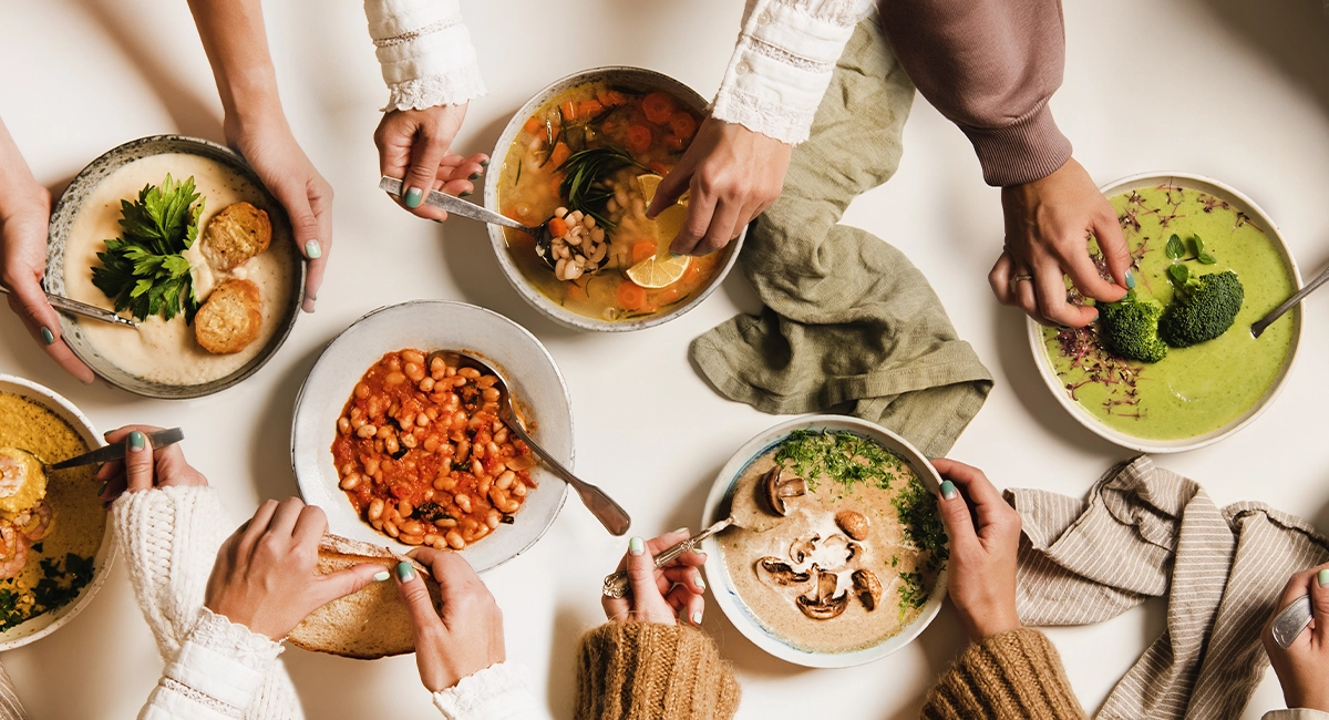 A variety of winter soups laid out on a table.