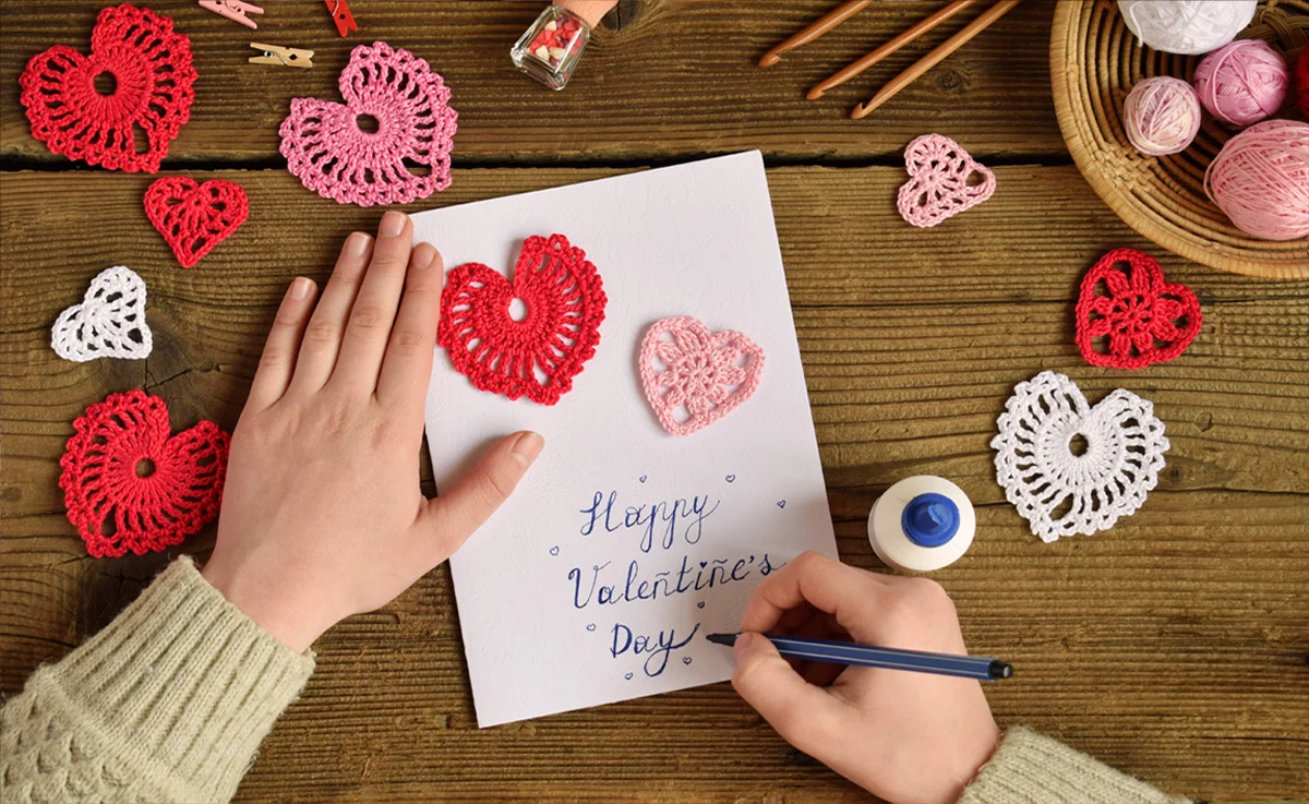 Making of handmade Valentine greeting card with crochet openwork hearts