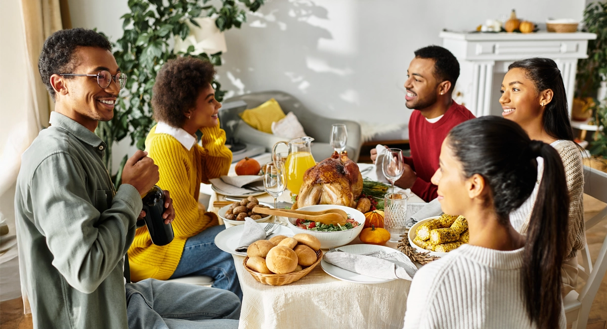 A group of friends dine together at a Friendsgiving gathering.