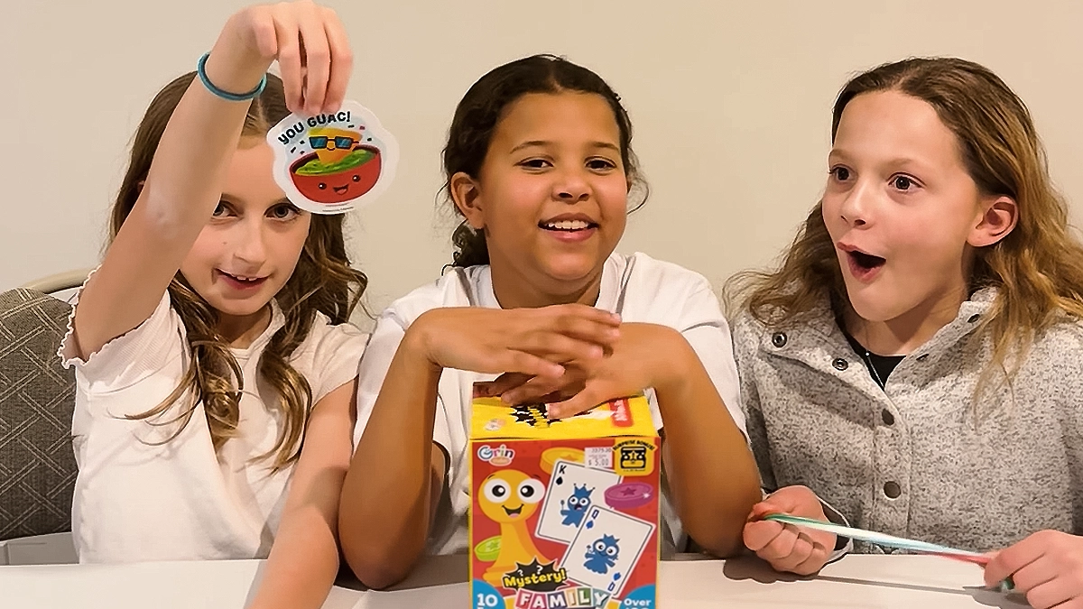 Three young girls unboxing a mystery toy box from Ocean State Job Lot