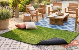 A selection of outdoor rugs sold at Ocean State Job Lot on display on a patio.