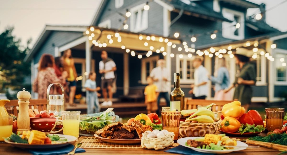 A summer cookout spread with family and friends in the background A summer cookout spread with family and friends in the background.