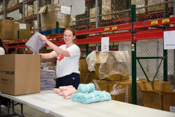 Ocean State Job Lot associates packing Operation Sleep Well Kits at the distribution center